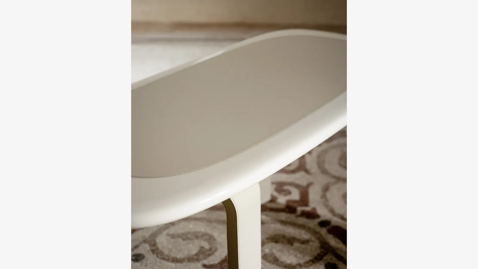 Tavolo Orbit in laccato con inserto e gambe in pelle di Tacchini