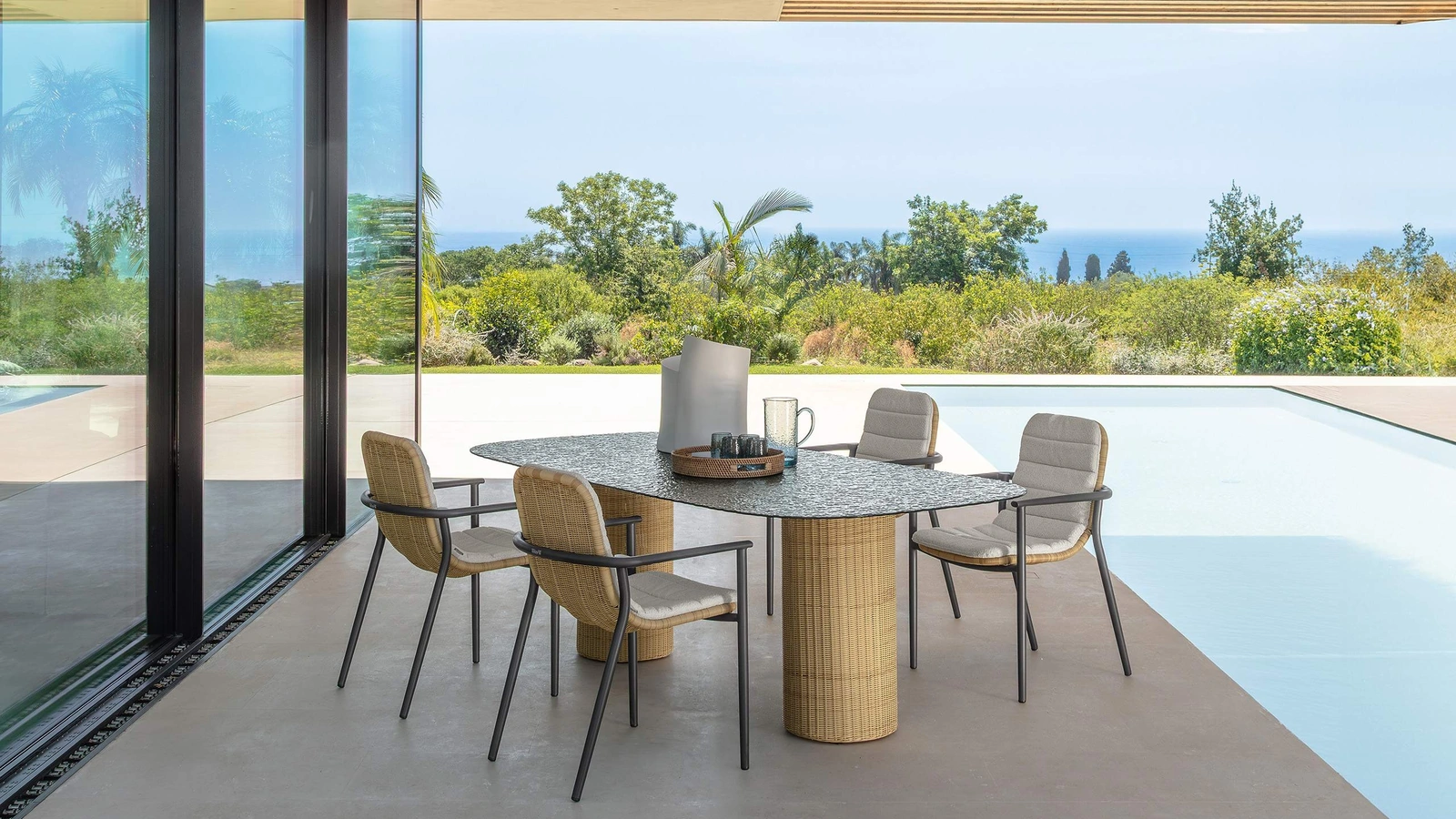 Tavolo in vetro e sedie in midollino Bond di Talenti